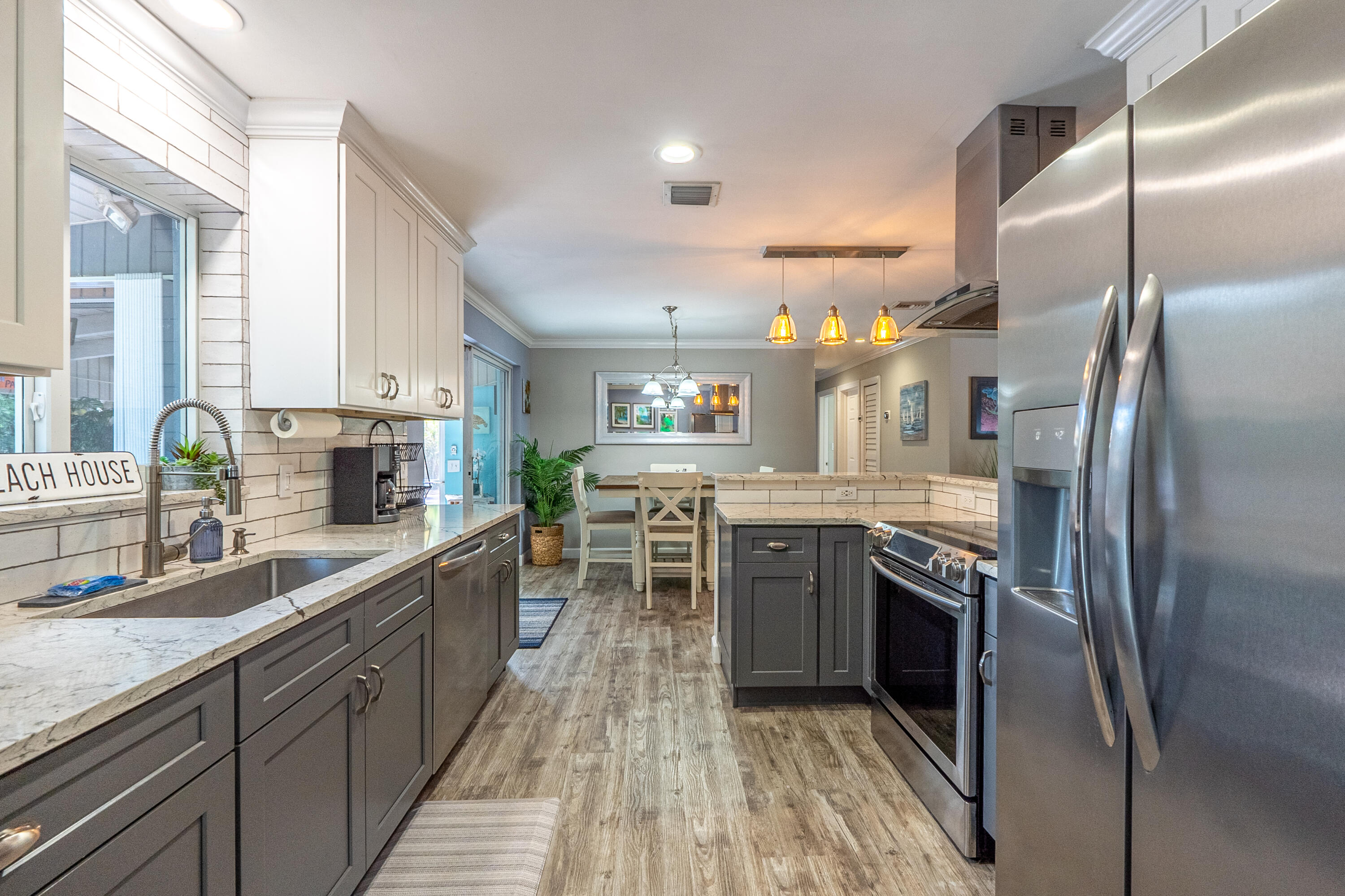 400 Pittsburgh Drive Jupiter, FL 33458 - Photo 10 of 30 a kitchen with stainless steel appliances granite countertop a sink a stove and a refrigerator