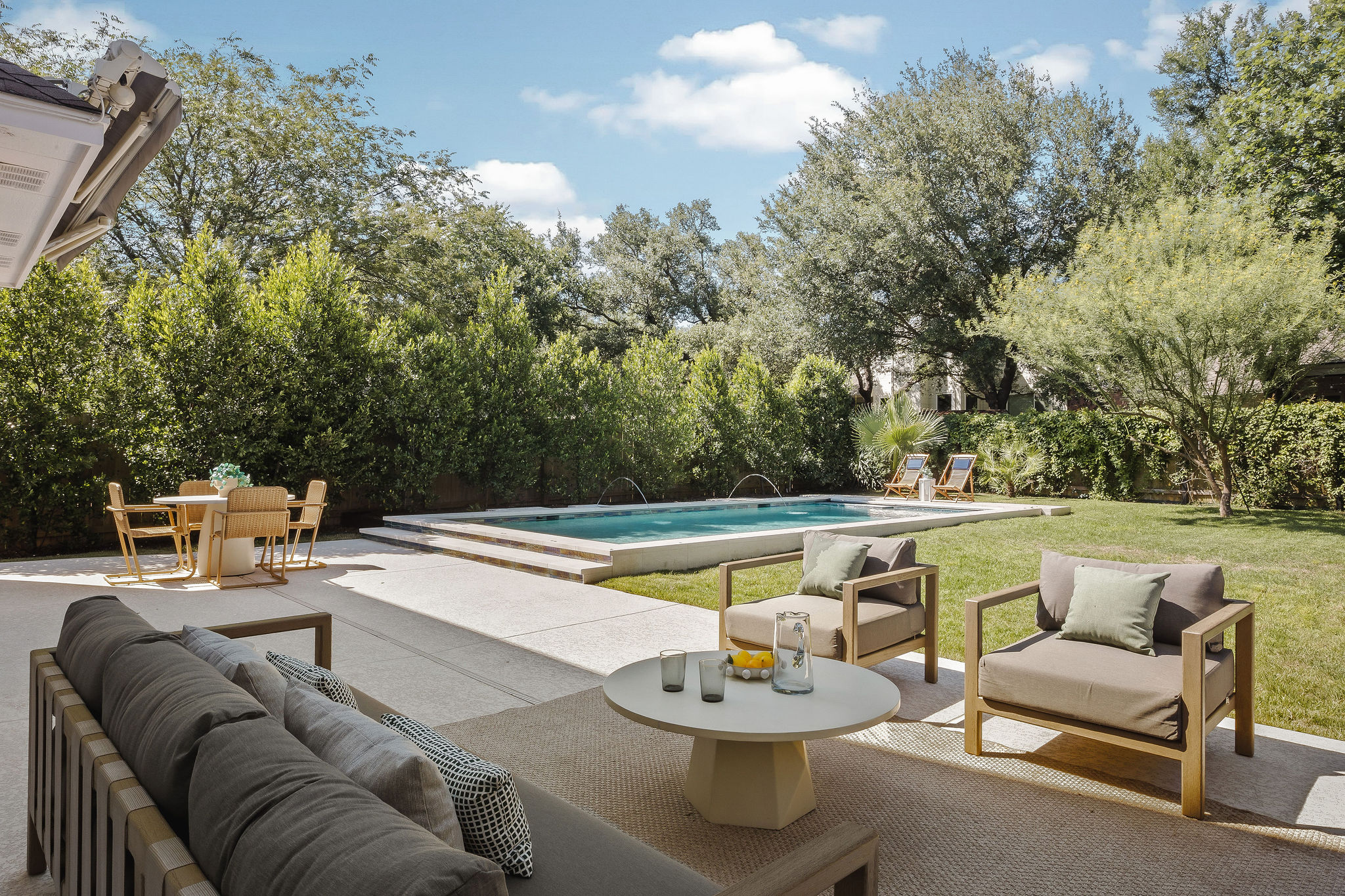 6500 Clay Allison Pass Austin, TX 78749 - Photo 34 of 39 Expansive backyard featuring a rectangular swimming pool with water features, a surrounding concrete patio, and a manicured lawn