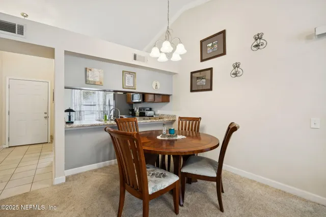 a living room with furniture a chandelier and a window