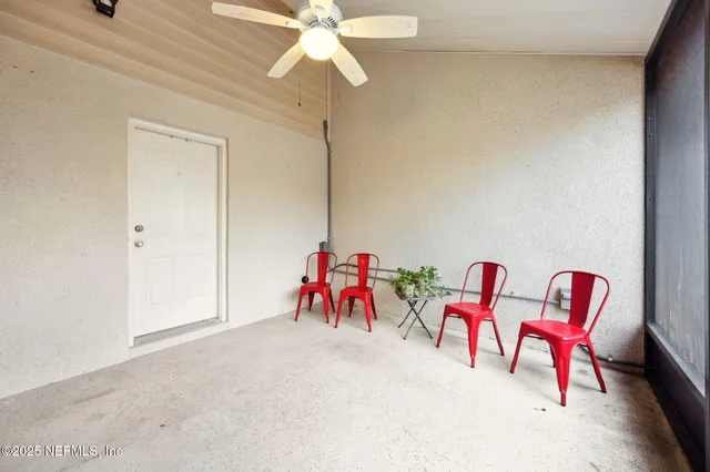a view of a backyard with table and chairs potted plants and large tree