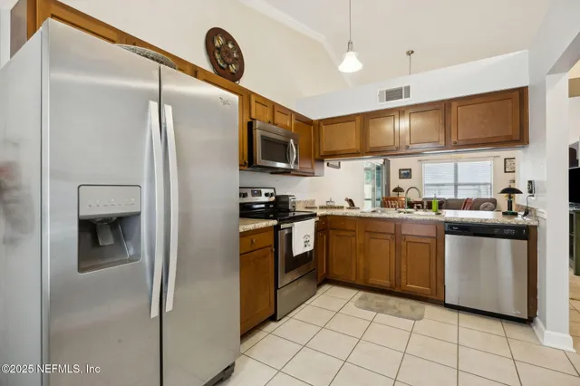 a living room with furniture and a dining table with kitchen view