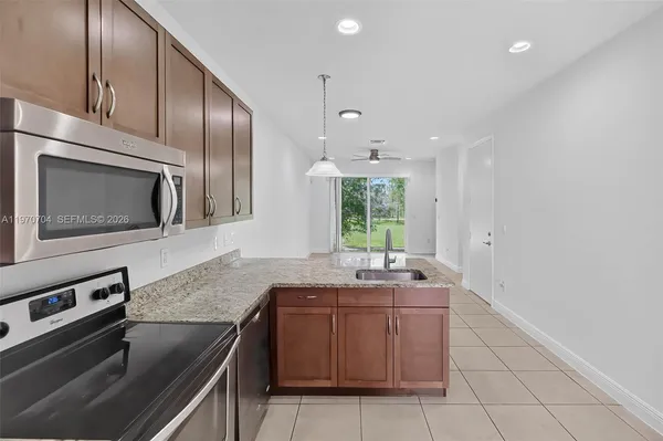 a kitchen with stainless steel appliances granite countertop a sink stove and microwave