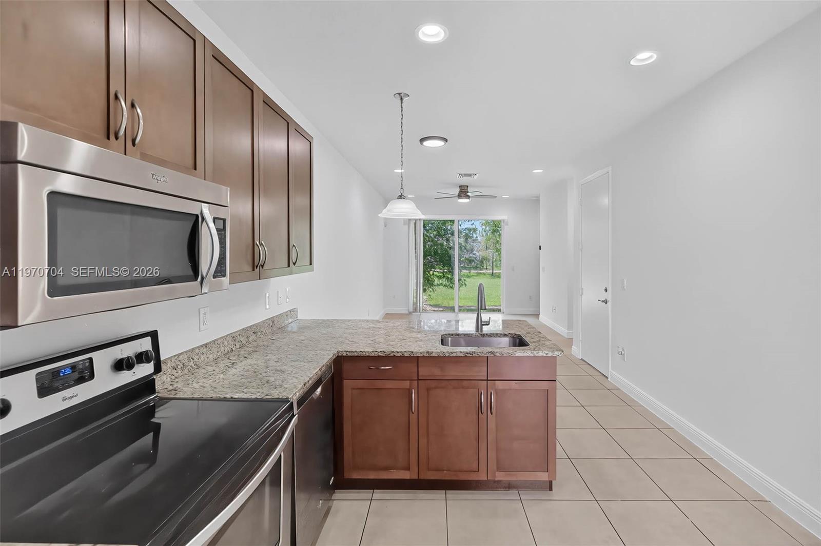 7651 North Pine Island Road Tamarac, FL 33321 - Photo 2 of 9 a kitchen with stainless steel appliances granite countertop a sink stove and microwave