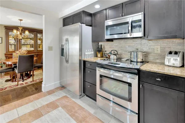 a kitchen with stainless steel appliances granite countertop a stove a sink and a refrigerator