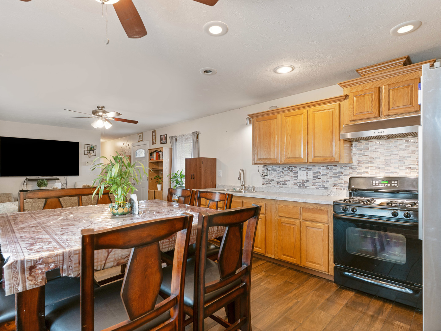 31 Peggy Drive Sandwich, IL 60548 - Photo 11 of 17 a kitchen with stainless steel appliances granite countertop a stove top oven a sink dishwasher a dining table and chairs with wooden floor