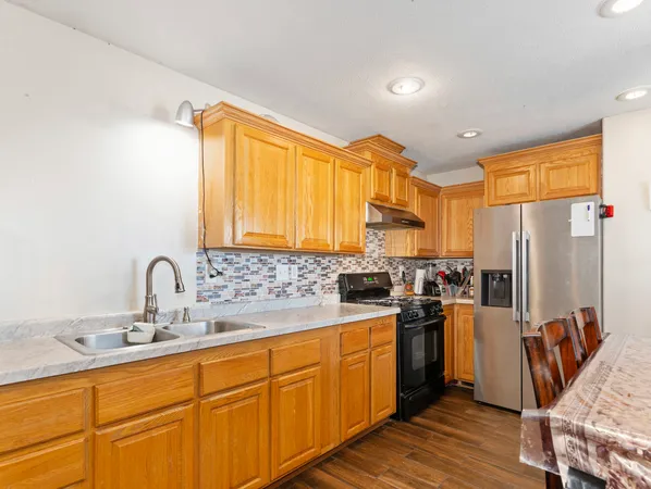 a kitchen with sink a refrigerator and wooden cabinets