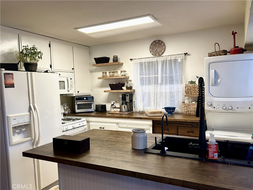 28639 Rostrata Avenue Lake Elsinore, CA 92532 - Photo 15 of 43 a kitchen with stainless steel appliances a sink a stove a refrigerator and cabinets