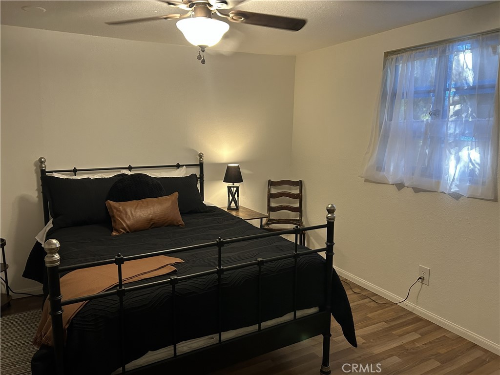 28639 Rostrata Avenue Lake Elsinore, CA 92532 - Photo 31 of 43 a bedroom with a bed and a chandelier