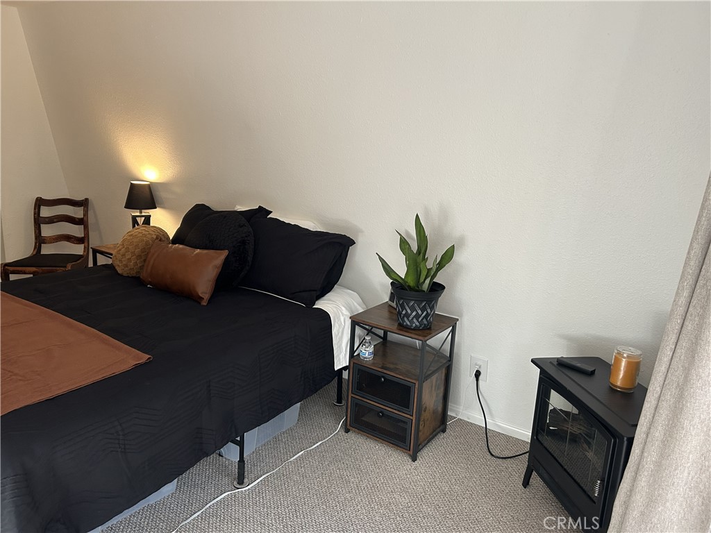 28639 Rostrata Avenue Lake Elsinore, CA 92532 - Photo 34 of 43 a bedroom with a bed and a potted plant