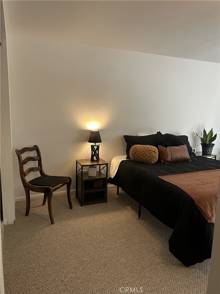 28639 Rostrata Avenue Lake Elsinore, CA 92532 - Photo 36 of 43 a bedroom with furniture and a lamp