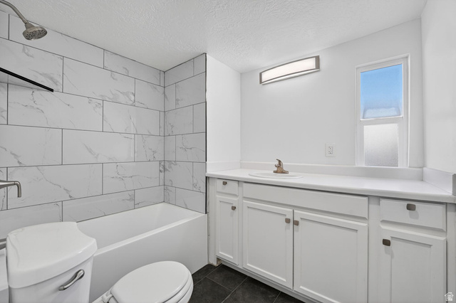 2491 Highway 89, Unit 523 Pleasant View, UT 84404 - Photo 17 of 31 UPDATED Bathroom featuring vanity, a textured ceiling, washtub / shower combination, and dark tile patterned floors
