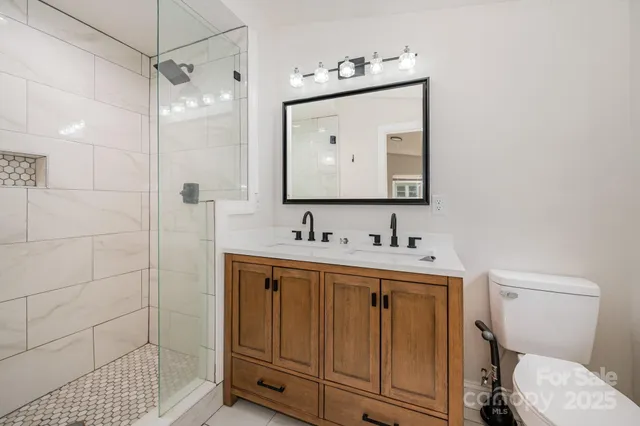 a bathroom with a toilet sink vanity and mirror