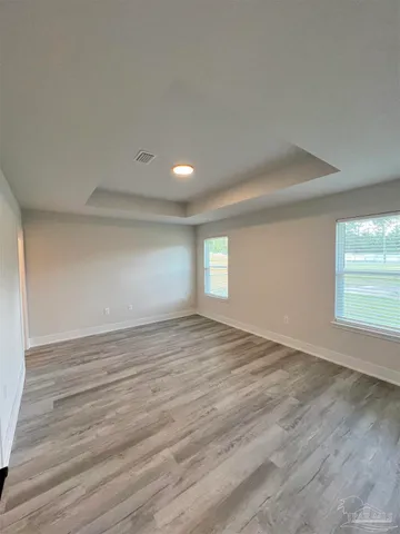 a view of empty room with window and wooden floor