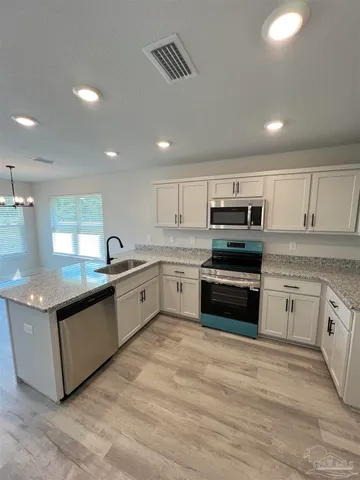 a large kitchen with stainless steel appliances granite countertop a stove and a sink