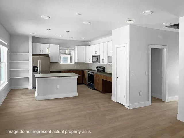 a view of kitchen with stainless steel appliances granite countertop a stove top oven a refrigerator a sink and a refrigerator