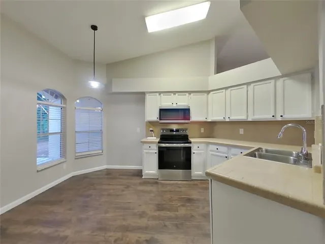 a kitchen with stainless steel appliances granite countertop a sink a stove and a refrigerator