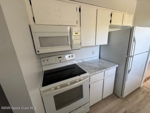 2232 Flower Tree Circle Melbourne, FL 32935 - Photo 4 of 13 a kitchen with white cabinets and white appliances