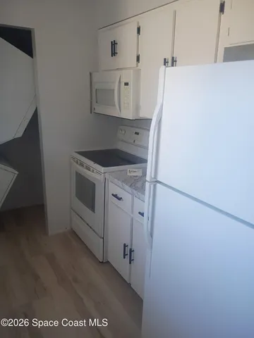 a kitchen with refrigerator and white cabinets