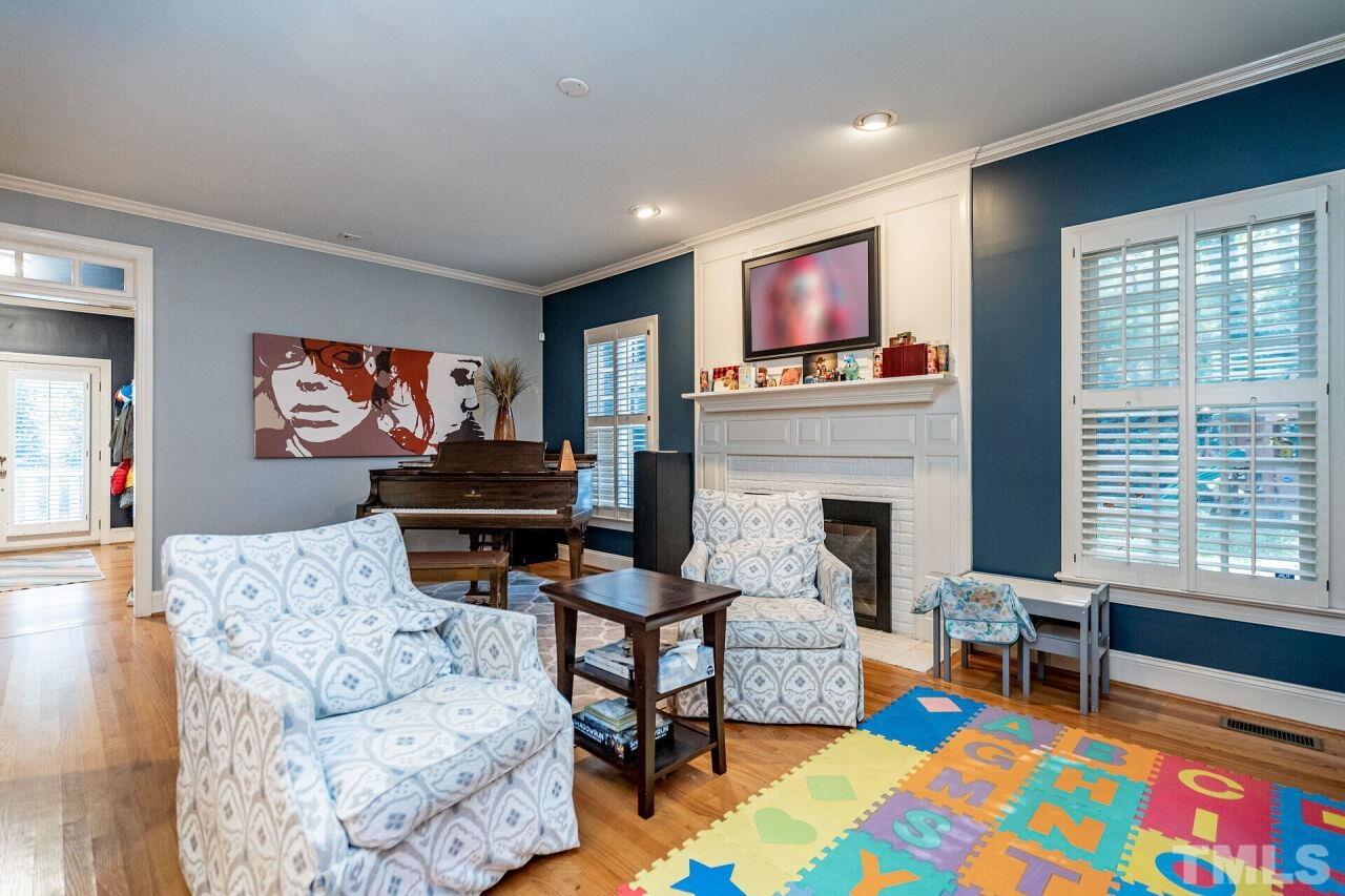 1904 White Oak Road Raleigh, NC 27608 - Photo 10 of 30 a living room with furniture a flat screen tv and a fireplace