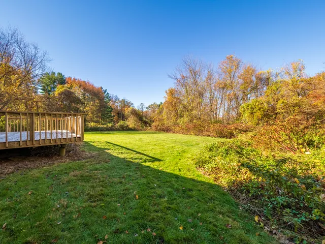 a view of a yard with wooden fence