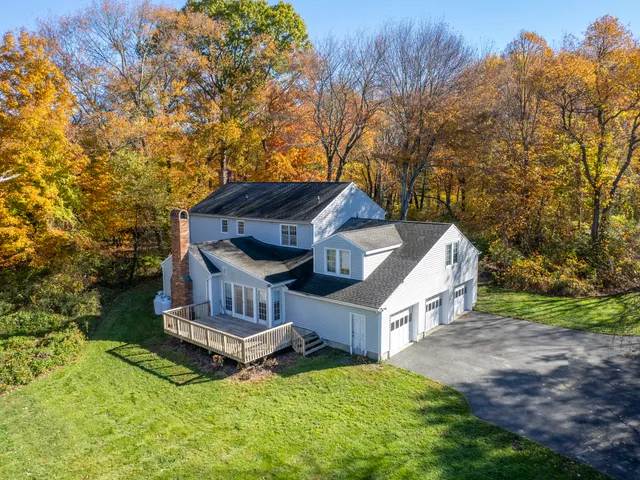 a view of a house with a yard and large trees