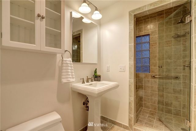 a bathroom with a sink a toilet and shower