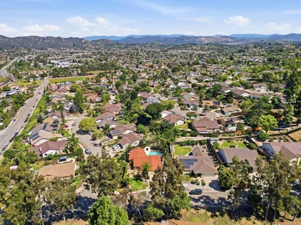 an aerial view of residential houses with outdoor space and trees
