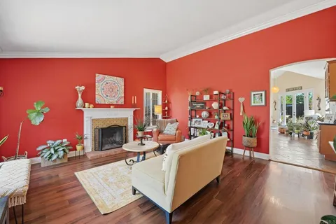 a living room with furniture a fireplace and a potted plant