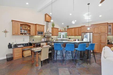 a kitchen with kitchen island a table and chairs in it
