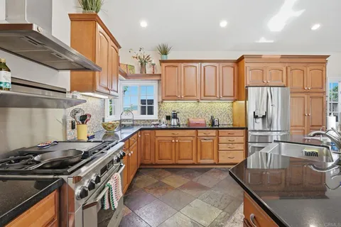 a kitchen with stainless steel appliances granite countertop a sink stove and refrigerator