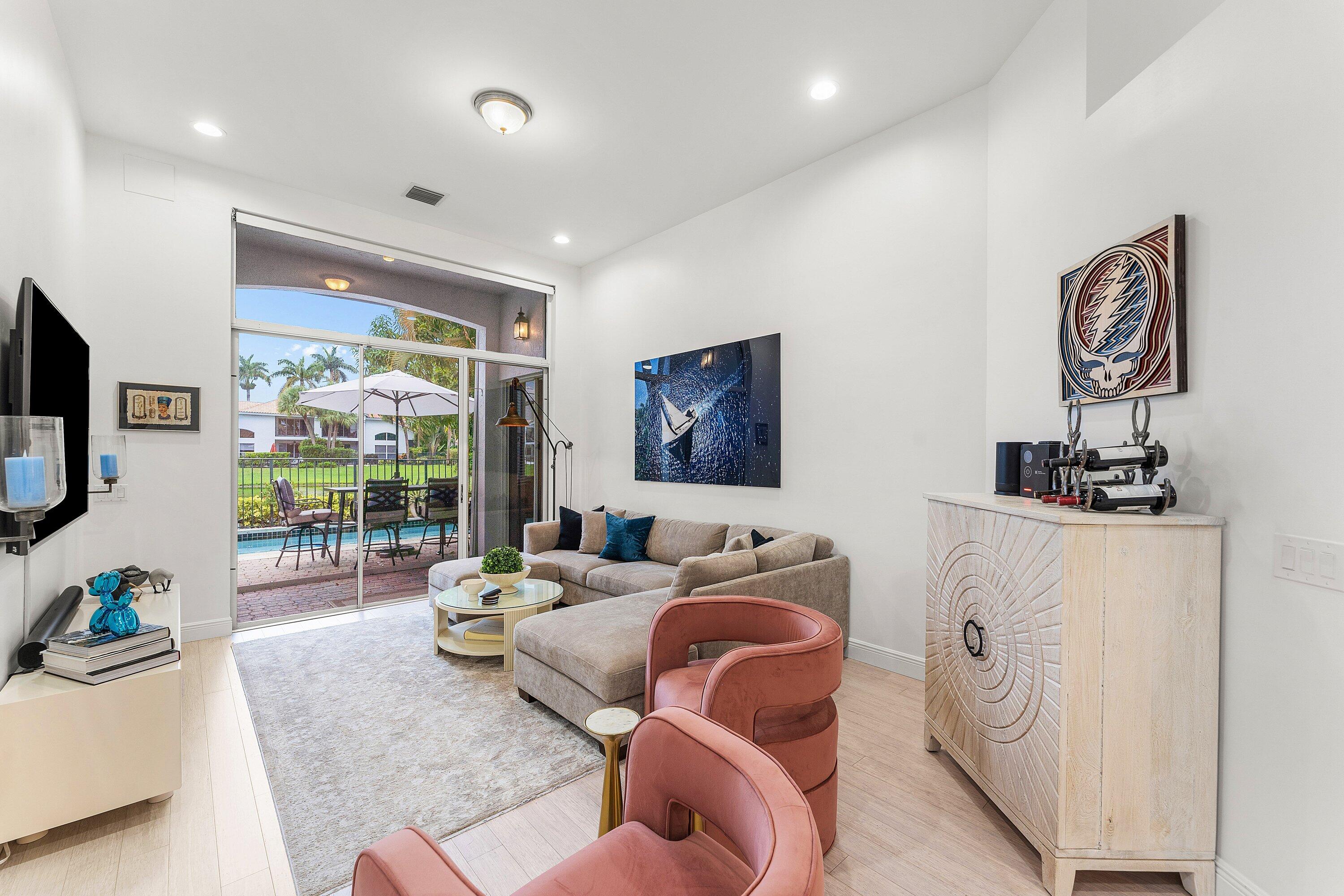 2221 Northwest 62nd Drive Boca Raton, FL 33496 - Photo 14 of 62 a living room with furniture a flat screen tv and a floor to ceiling window