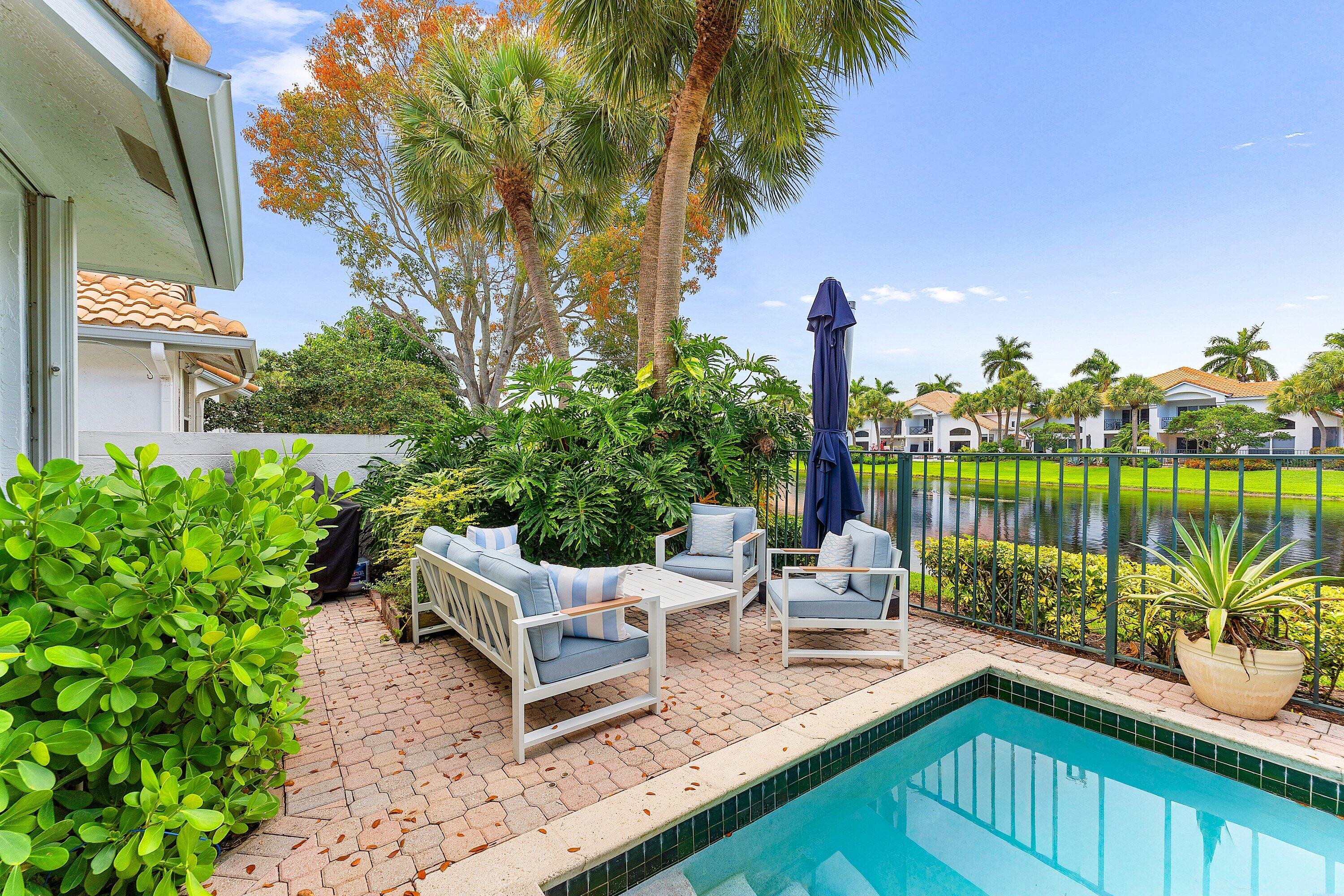 2221 Northwest 62nd Drive Boca Raton, FL 33496 - Photo 29 of 62 a view of a chair and tables in the patio next to a yard