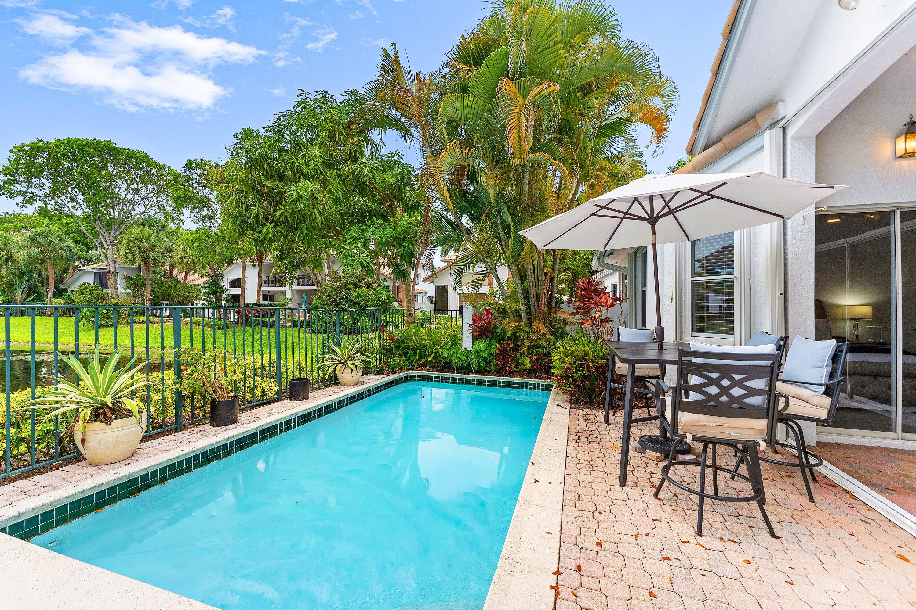 2221 Northwest 62nd Drive Boca Raton, FL 33496 - Photo 4 of 62 a view of a patio with a table and chairs under an umbrella