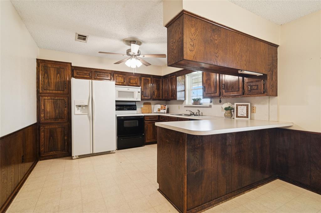 941 Maple Street Howe, TX 75459 - Photo 11 of 37 a kitchen with stainless steel appliances a sink a stove and refrigerator