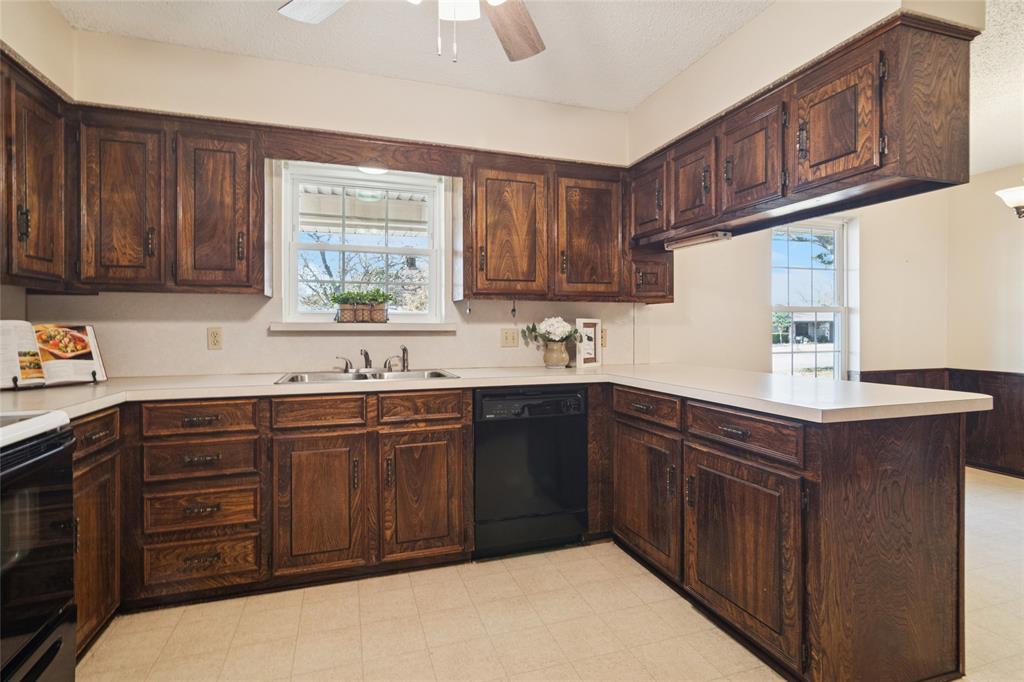 941 Maple Street Howe, TX 75459 - Photo 12 of 37 a kitchen with a sink and wooden cabinets
