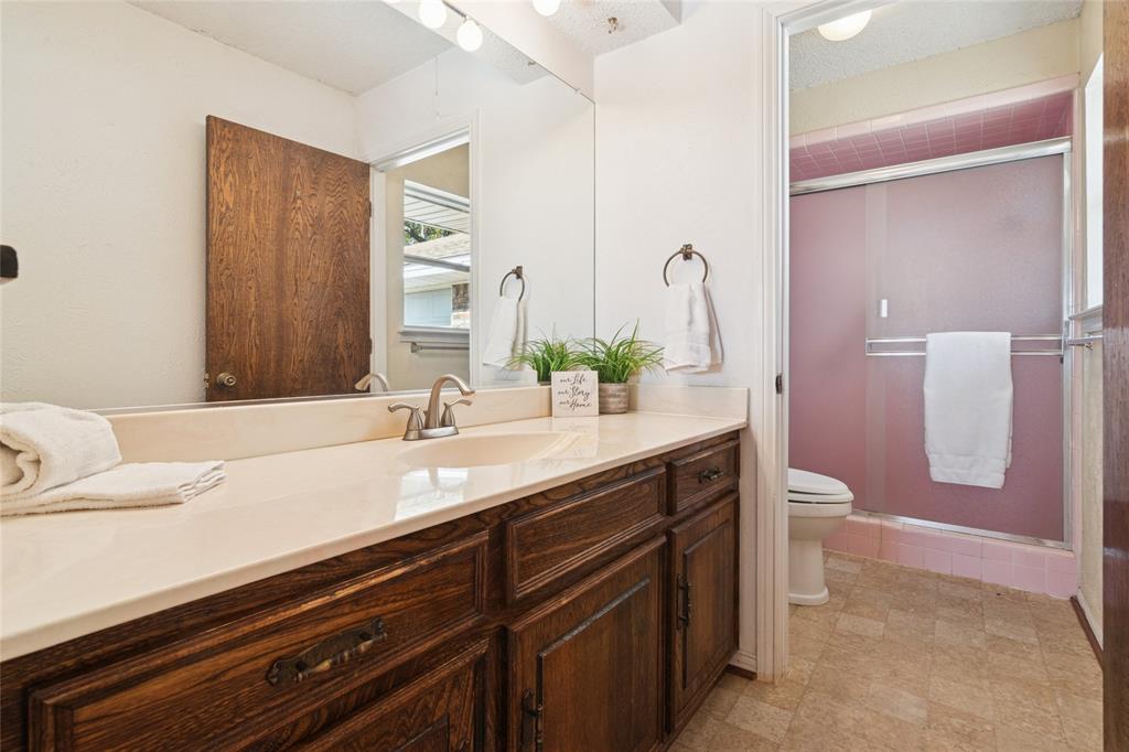 941 Maple Street Howe, TX 75459 - Photo 17 of 37 a bathroom with a granite countertop sink and a mirror