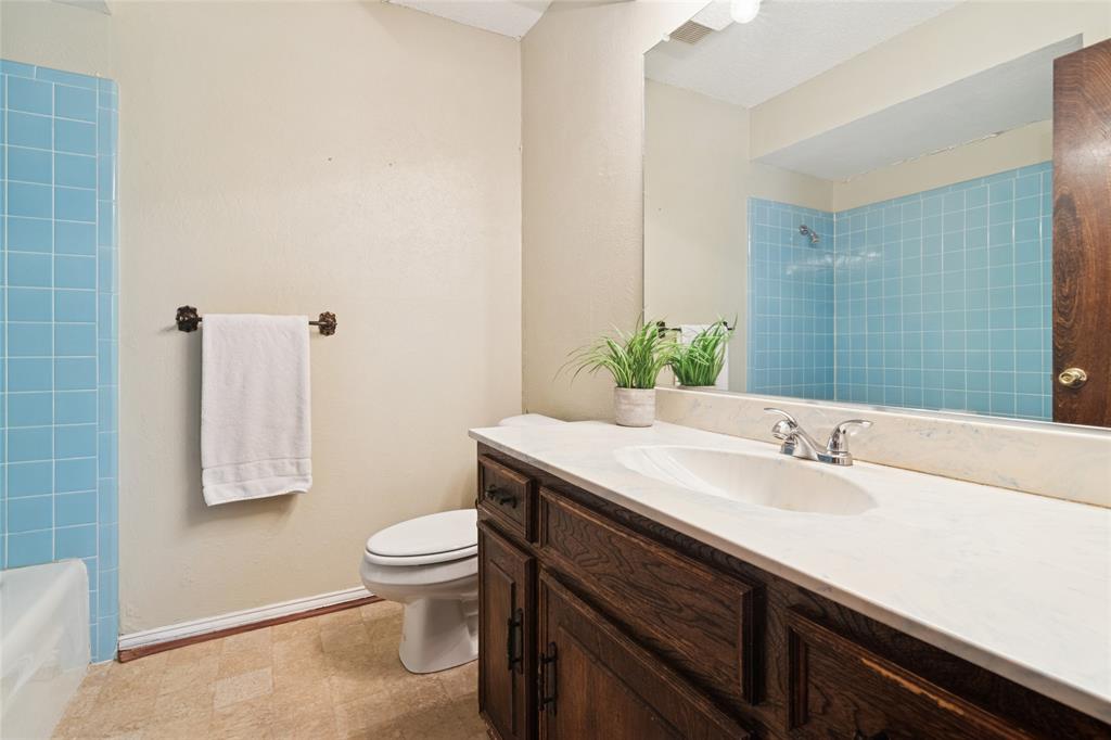 941 Maple Street Howe, TX 75459 - Photo 20 of 37 a bathroom with a granite countertop sink a toilet and a mirror