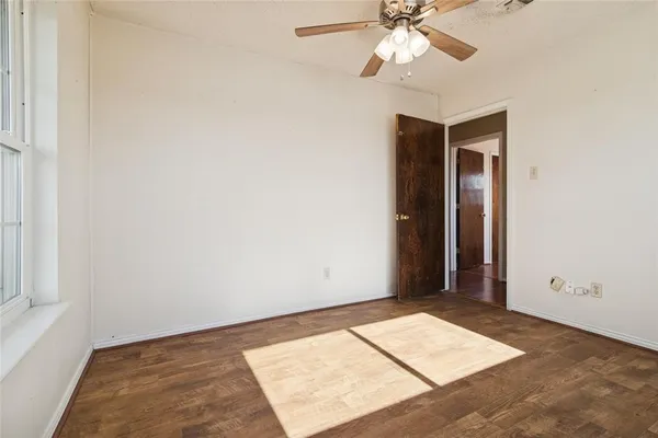an empty room with fan and a window