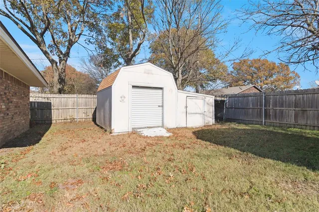 a bedroom with a bed and a potted plant on the dresser