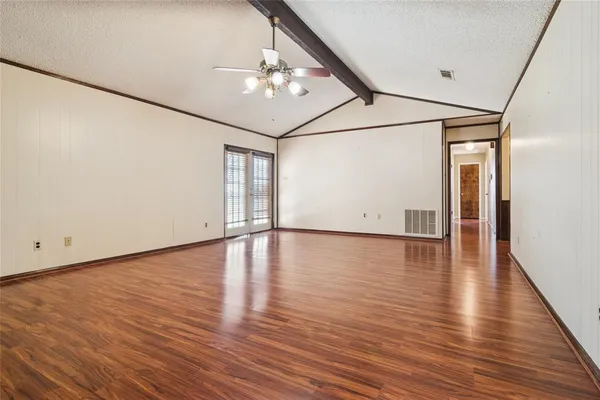 a view of an empty room with wooden floor