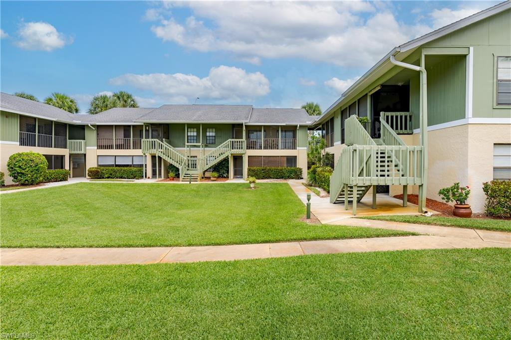 5501 Rattlesnake Hammock Road, Unit 601 Naples, FL 34113 - Photo 1 of 21 a front view of a house with a yard table and chairs
