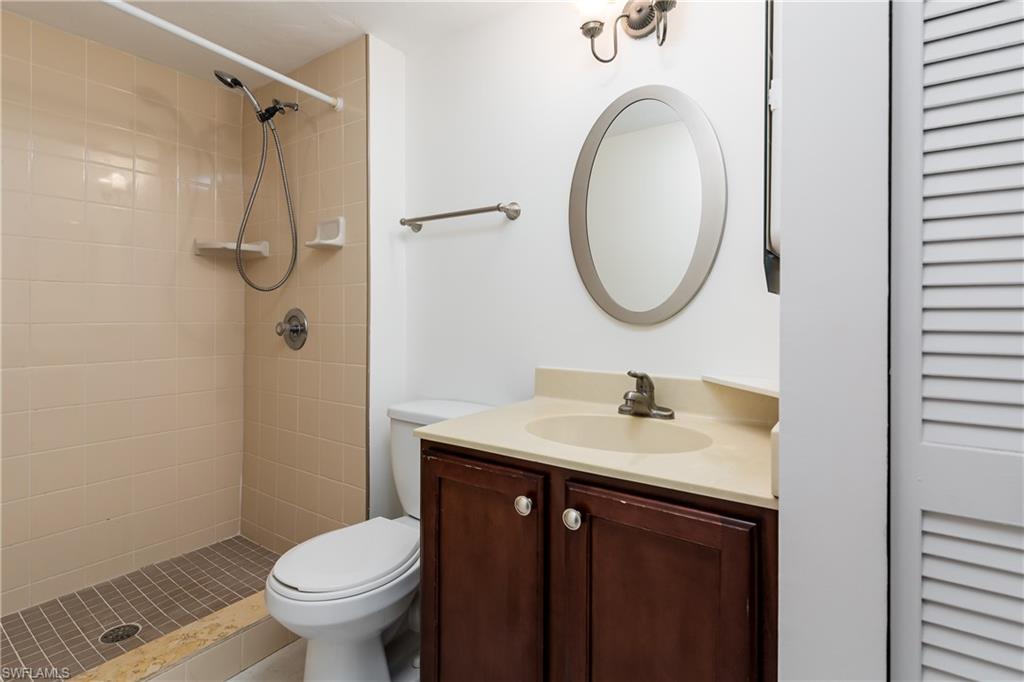 5501 Rattlesnake Hammock Road, Unit 601 Naples, FL 34113 - Photo 18 of 21 a bathroom with a granite countertop sink toilet and a mirror