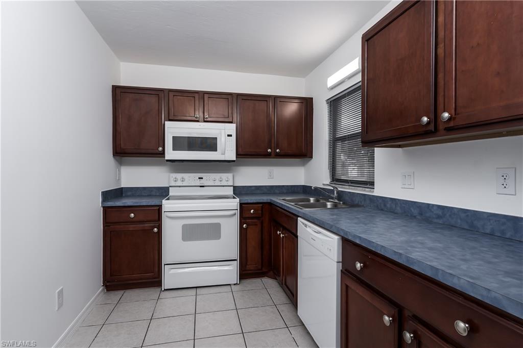 5501 Rattlesnake Hammock Road, Unit 601 Naples, FL 34113 - Photo 5 of 21 a kitchen with stainless steel appliances granite countertop a stove microwave and sink