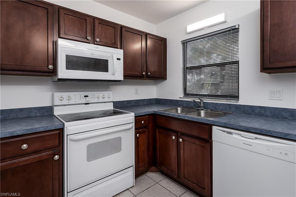 5501 Rattlesnake Hammock Road, Unit 601 Naples, FL 34113 - Photo 6 of 21 a kitchen with stainless steel appliances granite countertop a sink stove and microwave
