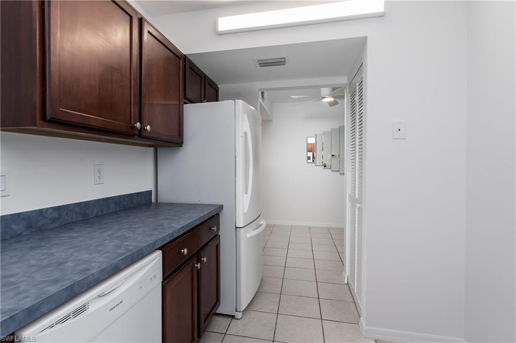 5501 Rattlesnake Hammock Road, Unit 601 Naples, FL 34113 - Photo 7 of 21 a kitchen with a refrigerator and cabinets