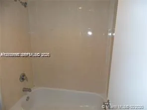 a white bath tub sitting next to a toilet