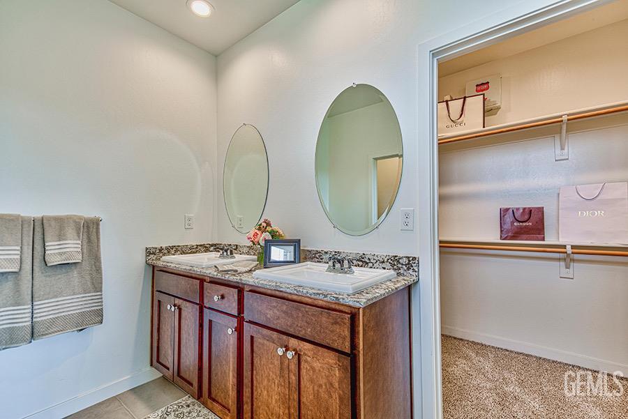 Undisclosed Address Bakersfield, CA 93311 - Photo 5 of 9 a bathroom with a granite countertop sink a mirror and a shower