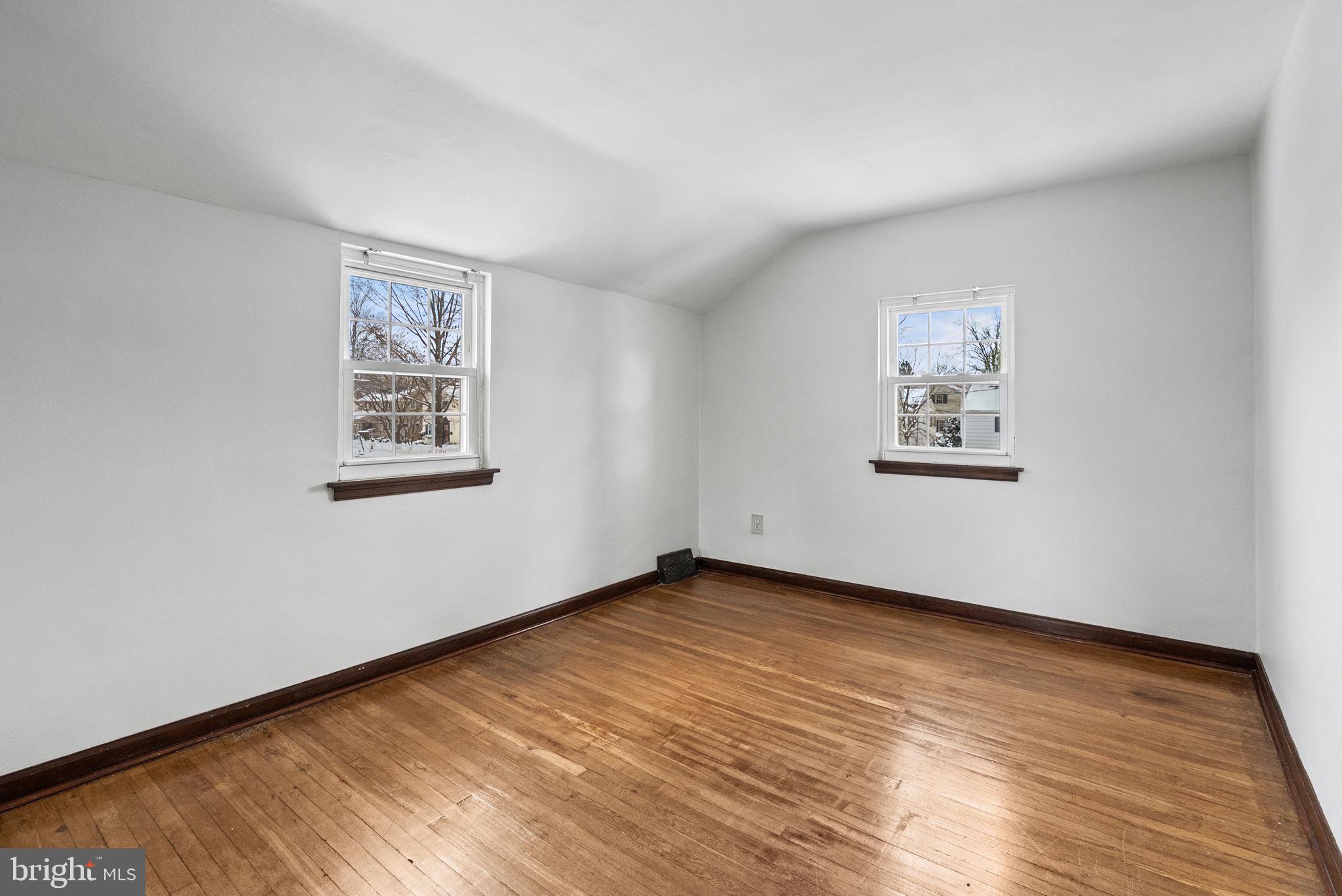 215 Allison Road Oreland, PA 19075 - Photo 22 of 39 a view of an empty room with wooden floor and a window