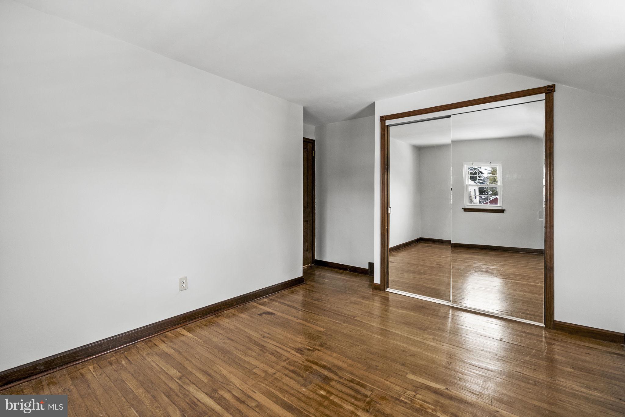 215 Allison Road Oreland, PA 19075 - Photo 23 of 39 an empty room with wooden floor and a window