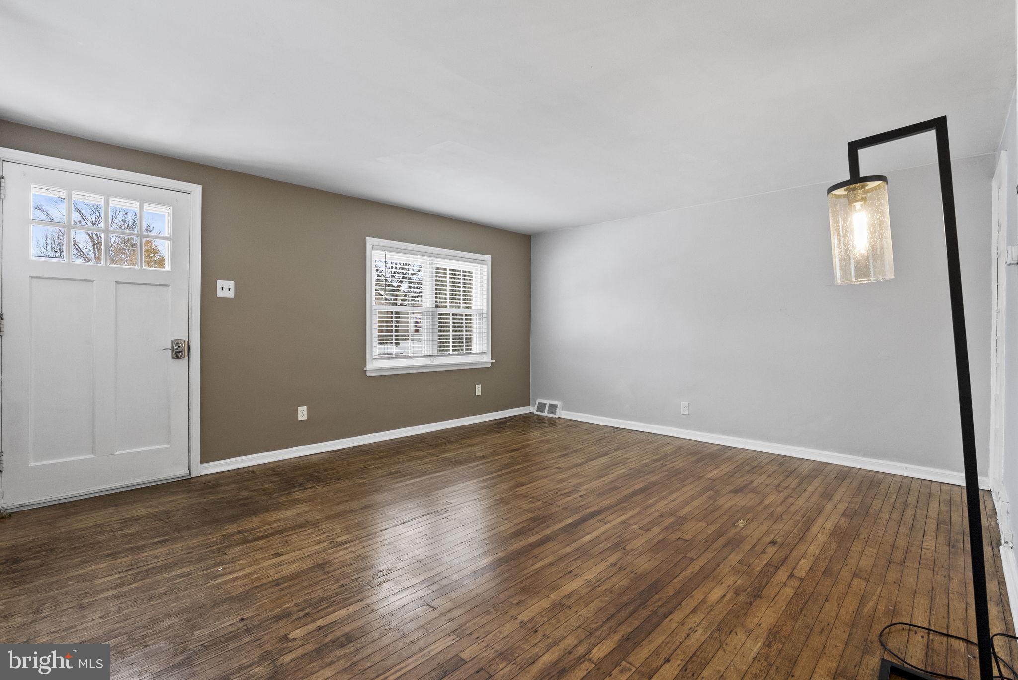 215 Allison Road Oreland, PA 19075 - Photo 7 of 39 an empty room with wooden floor and windows